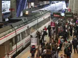 Varias personas esperan la llegada de su tren de Cercan&iacute;as este viernes en la estaci&oacute;n de Atocha.