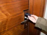 Una persona utiliza una tarjeta magnética para abrir una puerta.