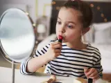 Una niña se maquilla con un pintalabios.