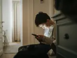 Un niño viendo su teléfono móvil