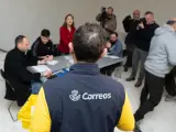 Un trabajador de Correos lleva los votos realizados por correo a la mesa electoral.