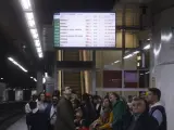 Varios pasajeros miran las pantallas de información en la estación de Sants, en un día donde la R3 está cortada por el robo de un cable.