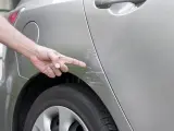 Un coche presenta un arañazo en uno de sus laterlares.