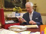 Carlos III, leyendo emocionado las cartas de apoyo de sus ciudadanos.