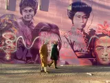 Dos personas pasan delante de El mural feminista de Ciudad Lineal que fue vandalizada con varias pintadas.