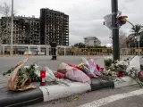 Flores, velas y algún peluche depositados ante el edificio incendiado de Valencia.