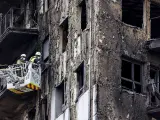 Bomberos en una grúa sanean la fachada quemada, a 26 de febrero de 2024, en Valencia.
