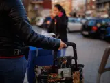 Una mujer hace cola con su carro de la compra a la espera de recibir regalos para niños vulnerables en una imagen de archivo.