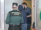 Dos agentes llevan al hombre detenido por haber agredido supuestamente a su pareja.