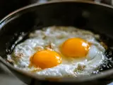 Dos huevos fritos en una sartén.