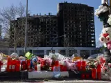 Detalle de flores, velas y peluches colocados a modo de homenaje ante el edificio incendiado en el barrio de Campanar de Valencia.