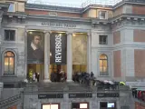 Decenas de personas con paraguas hacen cola en el exterior del Museo del Prado.