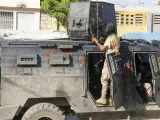 La policía se pone a cubierto durante una operación antipandillas en Puerto Príncipe, Haití, el viernes 1 de marzo de 2024.