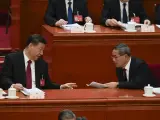 El presidente chino Xi Jinping, a la izquierda, habla con el primer ministro chino Li Qiang durante la sesión de apertura de la Asamblea Popular Nacional (APN) en el Gran Salón del Pueblo en Pekín, China, el martes 5 de marzo de 2024.