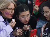 Varias chicas se pintan la cara durante la manifestaciones del 8M, a 8 de marzo de 2023 en M&aacute;laga (Andaluc&iacute;a, Espa&ntilde;a).