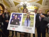La senadora Joni Ernst, republicana por Iowa, sostiene un cartel con fotos de las víctimas de asesinato Sarah Root y Laken Riley.