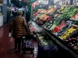 Una mujer realiza sus últimas compras antes de la cena de Nochebuena en un mercado, a 24 de diciembre de 2023, en Madrid (España).