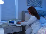 Una mujer maneja su máquina de diálisis en casa.