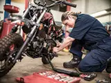 Una mecánica lleva a cabo tareas de mantenimiento de una motocicleta.