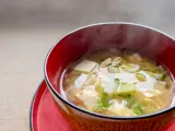 Sopa de miso con rábano y tofu en un tazón rojo Sopa de miso con rábano y tofu en un tazón rojo