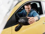 Un conductor regula el espejo retrovisor de su coche.