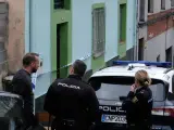 Agentes de la Policía Nacional hablan con un vecino de la localidad de La Felguera, en el municipio de Langreo (Asturias) frente a la vivienda donde habían sido hallados restos humanos.