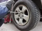 Un mec&aacute;nico ajusta las tuercas de la rueda del coche.