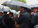 M&uacute;sicos de la Hermandad del Cautivo de San Pablo se marchan tras suspenderse por la lluvia su estaci&oacute;n de penitencia.