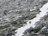Dos personas pasean sobre un paisaje nevado esta Semana Santa en Navacerrada.