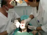 Dos odontólogos del Servicio Andaluz de Salud (SAS) atienden a una niña.