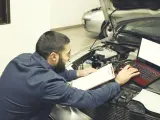 Un mecánico reprograma un coche en su taller.