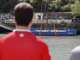 Un aficionado observa la Gabarra del Athletic en las aguas de la ría de Bilbao.