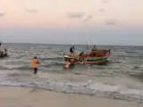 Locales ayudando a las víctimas del naufragio en una playa de la costa de Nampula.