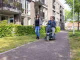 Dos personas, una de ellas en silla de ruedas, paseando.