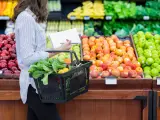 Una mujer comprando frutas y verduras.