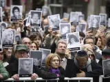 La gente sostiene las fotos de las personas que murieron durante el atentado en el centro judío AMIA que mató a 85 personas en el 25 aniversario del ataque en Buenos Aires, Argentina, que se cumplió en 2019.