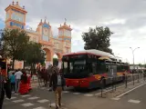 Un autobús de Tussam pasando junto a la Portada de la Feria de una edición anterior.