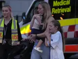 Una mujer y sus hijos salen del centro comercial de Sydney donde se produjo el ataque.