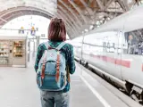 Una joven con una mochila en el andén de un tren.