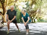 Dos personas maduras haciendo ejercicio al aire libre.