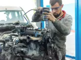 Un mecánico reparando el motor de un coche.