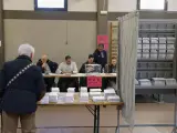 Un hombre escoge papeleta para ejercer su derecho al voto en un colegio electoral en Durango, Vizcaya.