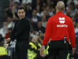 Xavi Hernández protesta al quinto árbitro durante el Clásico en el Santiago Bernabéu.