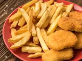 Un plato de patatas fritas y nuggets caseros.