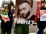 Una mujer sostiene un retrato del rapero Toomaj Salehi durante una manifestación.