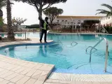 Un trabajador limpiando la piscina del camping Les Medes de l'Estartit (Girona).