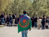 Una persona con una bandera gitana a su espalda durante el acto conmemorativo del Día Internacional del Pueblo Gitano en Madrid.