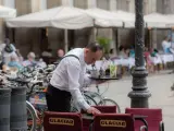 Un camarero limpia una mesa en la plaza Real de Barcelona en una imagen de archivo.