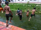 Varios niños se lanzan a un río en Bangladés, donde hay temperaturas de 43 grados