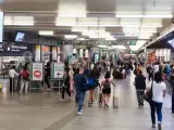 Varias personas caminan con maletas en la estación de Puerta de Atocha-Almudena Grandes